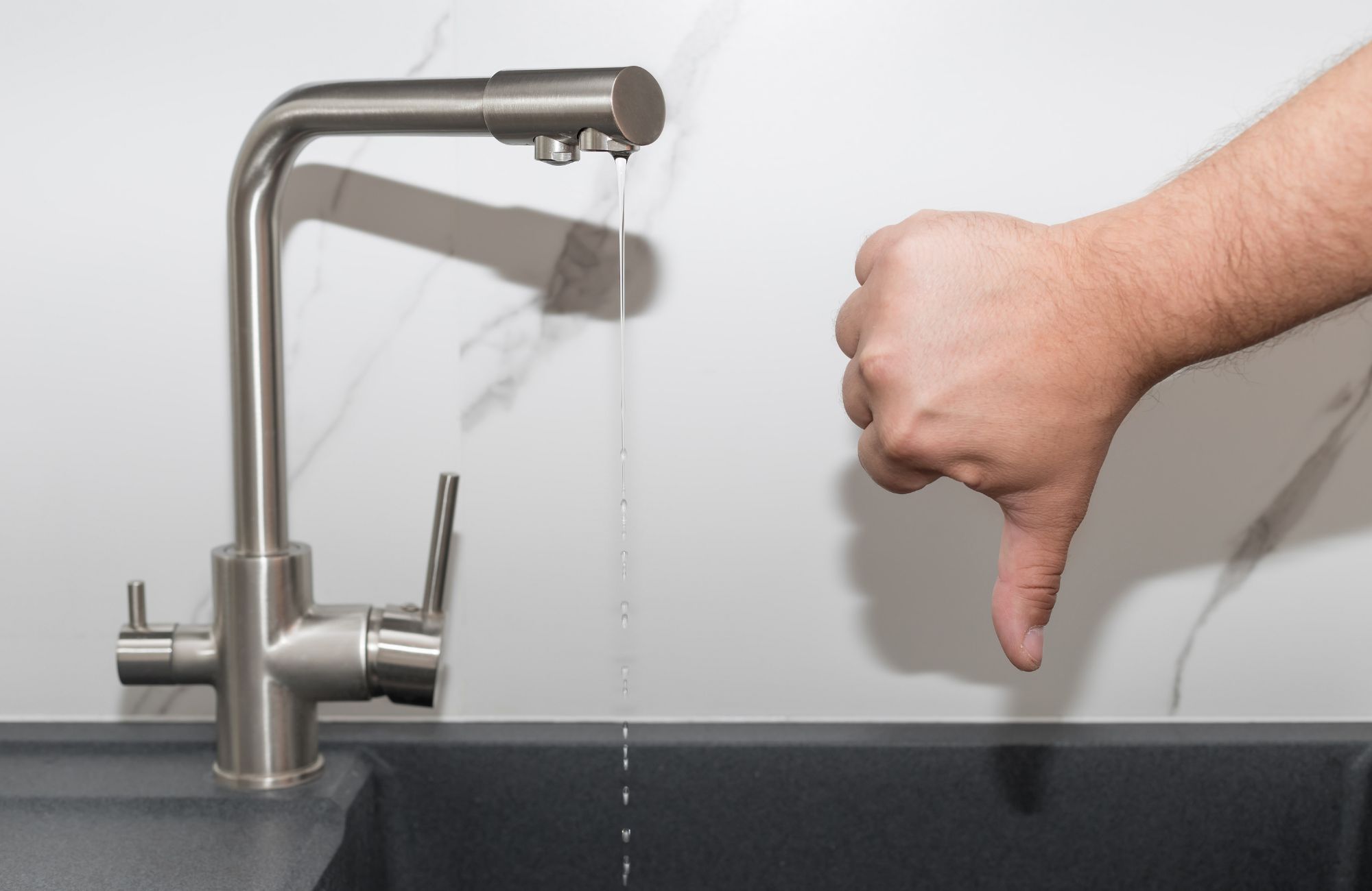 Kitchen tap with bad pressure flowing water. water shortage